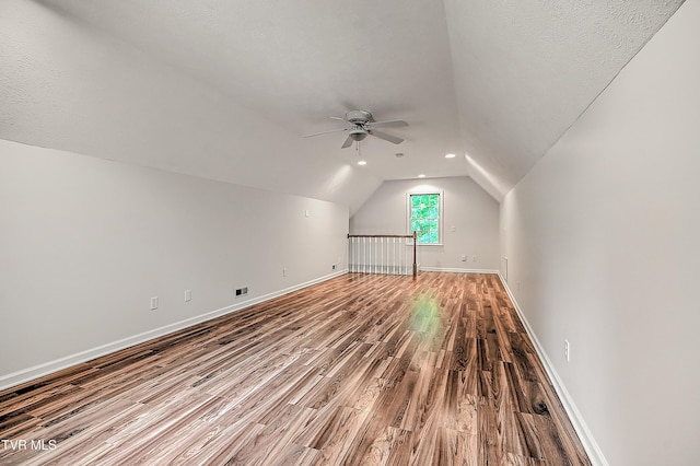 bonus room with lofted ceiling, wood finished floors, baseboards, recessed lighting, and a ceiling fan
