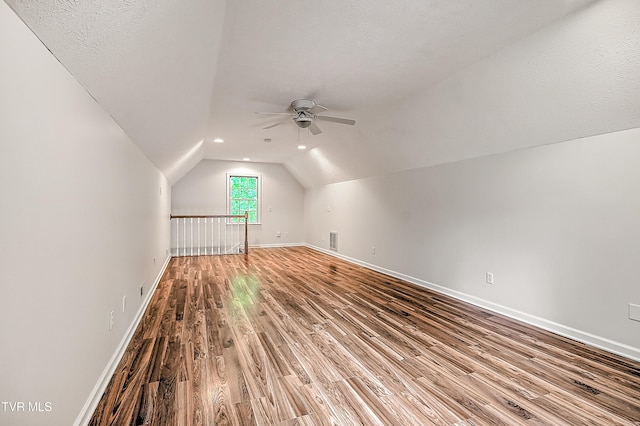 bonus room featuring ceiling fan, visible vents, wood finished floors, baseboards, and lofted ceiling