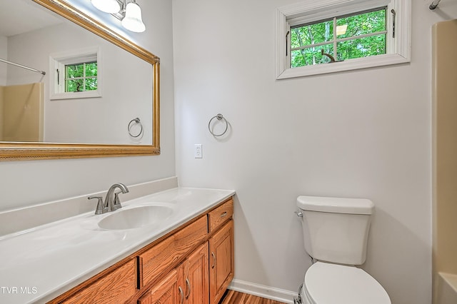 full bathroom with vanity, walk in shower, a healthy amount of sunlight, and toilet