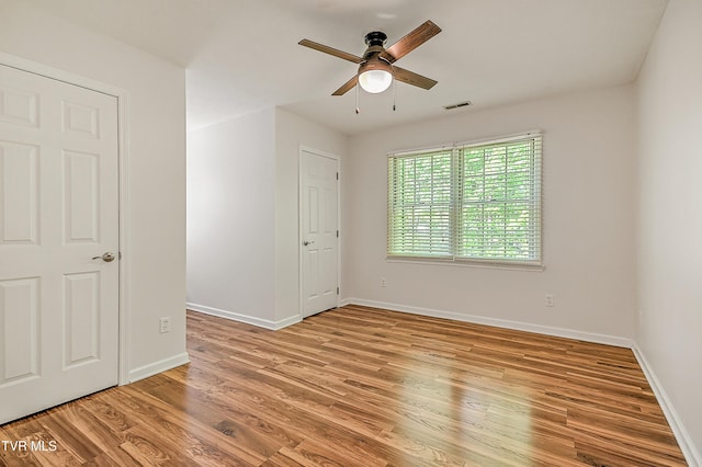 unfurnished bedroom with baseboards, ceiling fan, light wood-style flooring, and visible vents