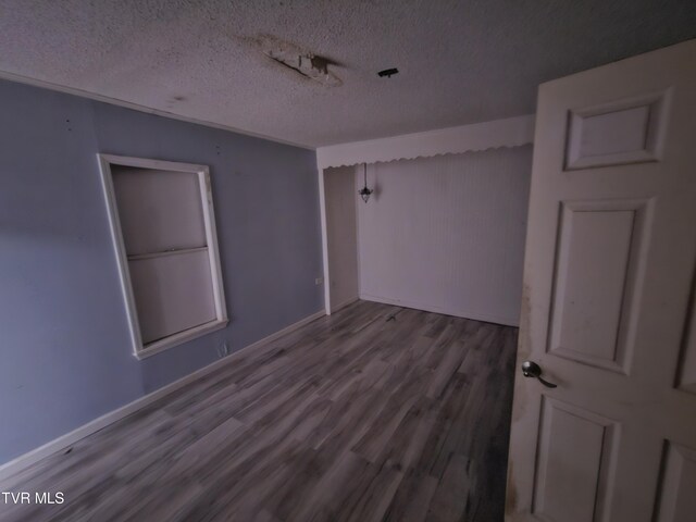 7231 Rocky Fork Rd, Wise, VA 24293 - empty room with wood finished floors and a textured ceiling