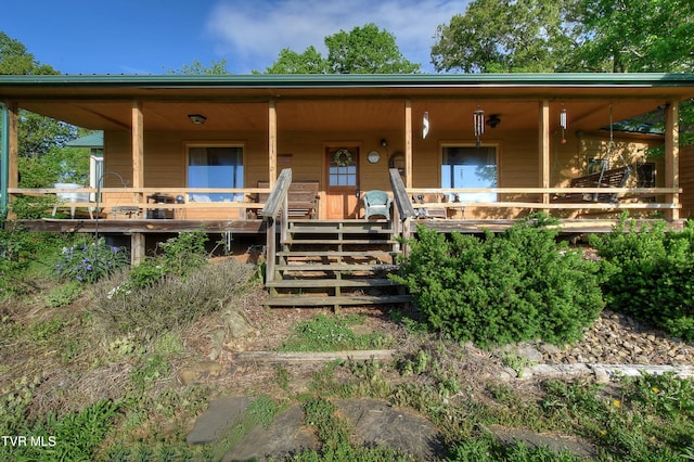 view of front of property featuring covered porch and stairway