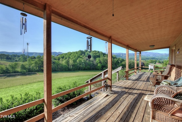 deck with a yard and a mountain view