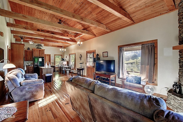living area featuring a wealth of natural light, a notable chandelier, wooden ceiling, and light wood-type flooring