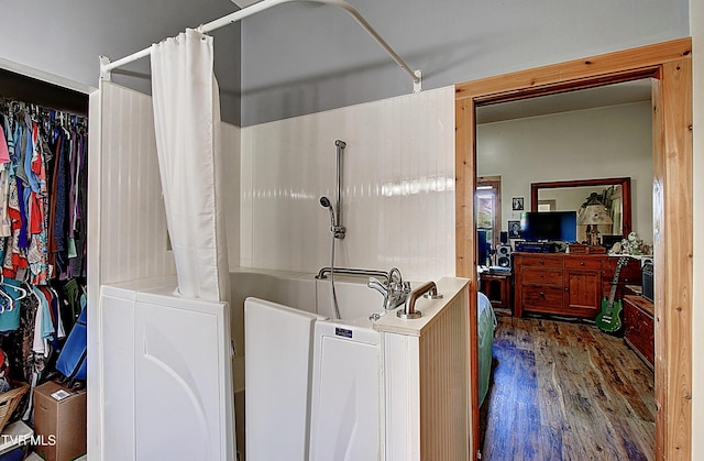 laundry room featuring separate washer and dryer and wood finished floors