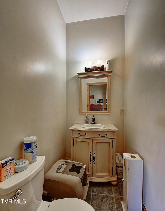 half bathroom featuring toilet, tile patterned floors, and vanity