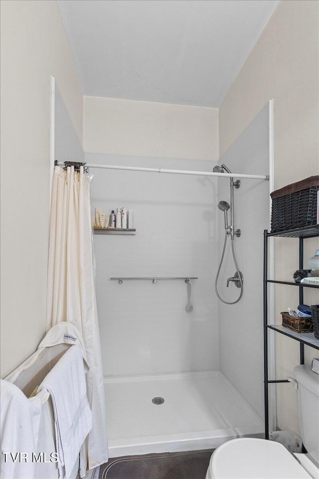 full bath with a shower with shower curtain and toilet