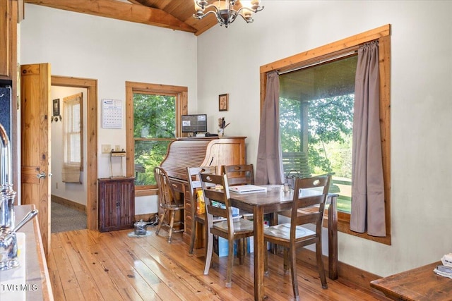 dining area with a notable chandelier, light wood-style floors, high vaulted ceiling, baseboards, and wood ceiling