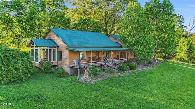 back of property with a porch, a yard, metal roof, and a sunroom