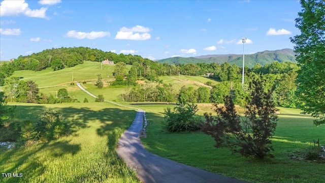 surrounding community featuring a lawn and a mountain view