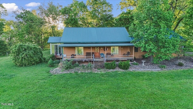 rear view of house with a porch, a yard, and metal roof