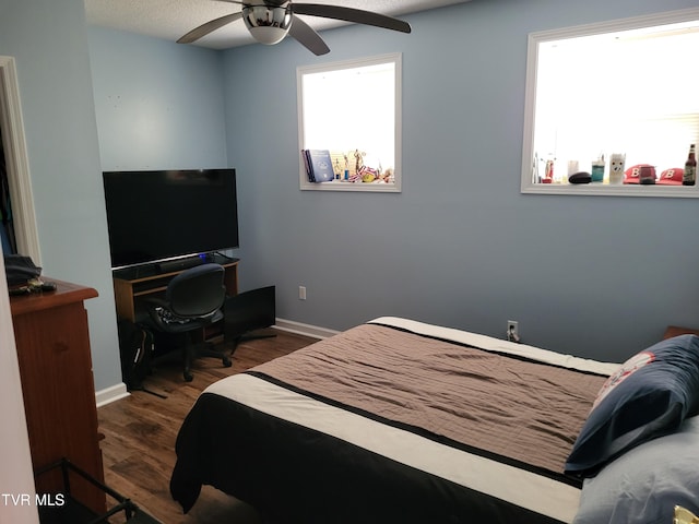 bedroom with baseboards, ceiling fan, and wood finished floors