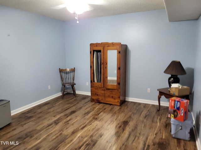 miscellaneous room featuring dark wood-type flooring, a ceiling fan, and baseboards