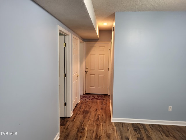 hallway with dark wood-style flooring and baseboards