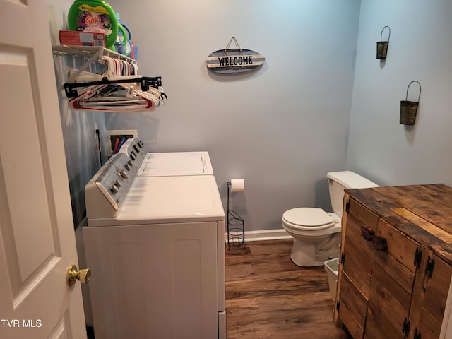 bathroom featuring toilet, baseboards, washer and clothes dryer, and wood finished floors