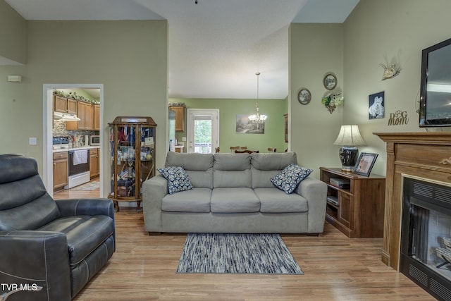 115 Maple Ridge Dr, Jonesborough, TN 37659 - living room featuring a chandelier, a fireplace, light wood-style floors, and vaulted ceiling