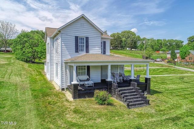 rear view of house with roof with shingles, a yard, and a porch