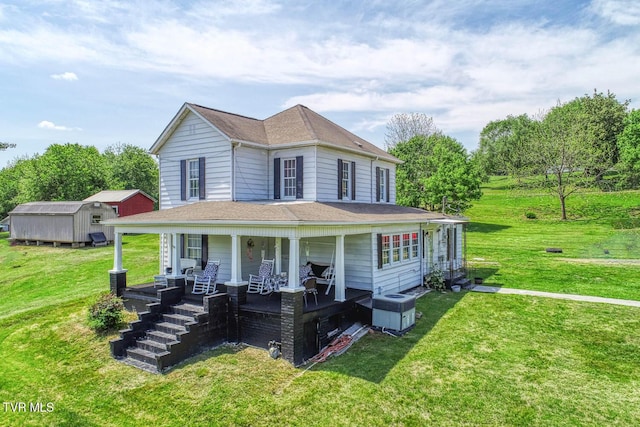 farmhouse with covered porch, cooling unit, an outdoor structure, a shed, and a front lawn