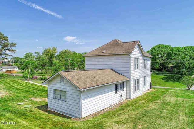 view of home's exterior with a lawn and roof with shingles