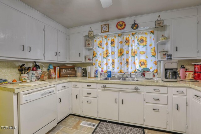 kitchen featuring light countertops, open shelves, a sink, and dishwasher