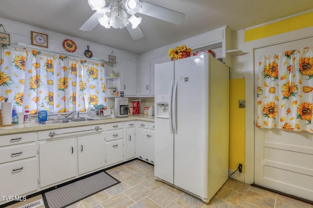 kitchen featuring ceiling fan, white refrigerator with ice dispenser, light countertops, white cabinets, and a sink