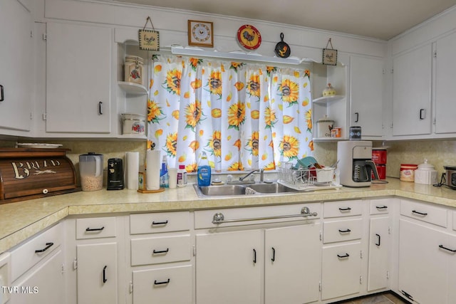 kitchen featuring light countertops, white cabinetry, open shelves, and a sink