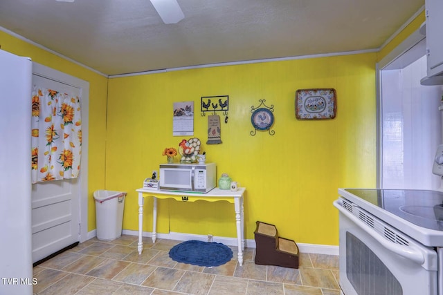 kitchen with white appliances, baseboards, and ornamental molding