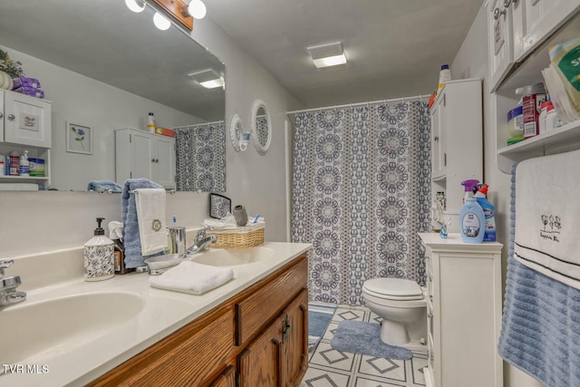bathroom featuring double vanity, a sink, toilet, and a shower with curtain