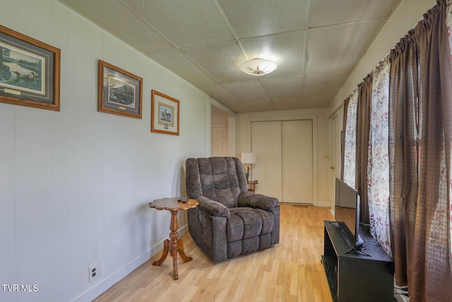 sitting room featuring baseboards and light wood finished floors