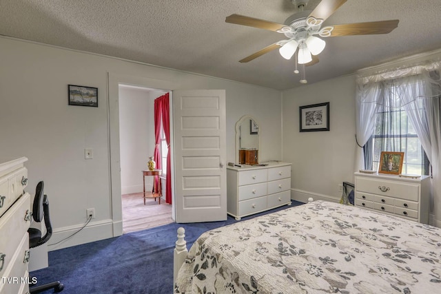 bedroom featuring dark colored carpet, a ceiling fan, and a textured ceiling