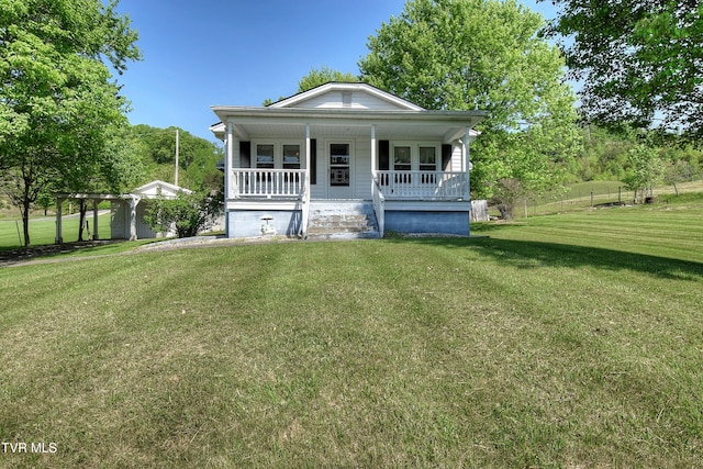 view of front of house with fence, a porch, a front lawn, and a garage