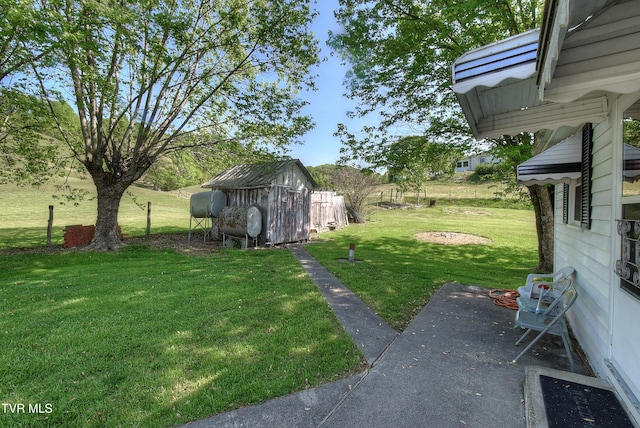view of yard featuring heating fuel, an outdoor structure, a patio area, and a storage unit