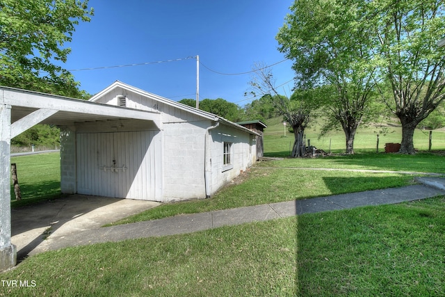 view of side of home with concrete block siding and a yard