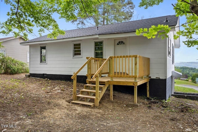 back of house with roof with shingles, a wooden deck, and crawl space