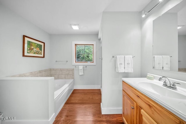 342 Ripshin Lake Rd, Roan Mountain, TN 37687 - full bath featuring baseboards, vanity, wood finished floors, and a garden tub