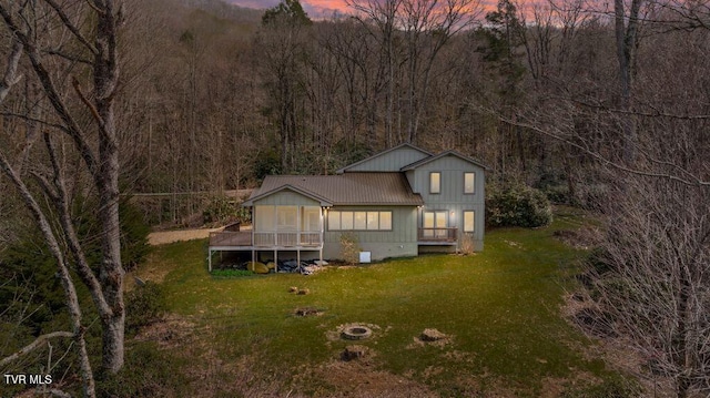 342 Ripshin Lake Rd, Roan Mountain, TN 37687 - exterior space with metal roof, a lawn, a wooden deck, a view of trees, and a fire pit