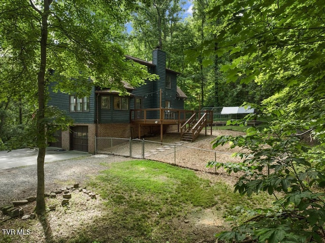 1008 Cox Trail Pl, Kingsport, TN 37660 - rear view of house featuring a deck, driveway, a chimney, an attached garage, and stairs