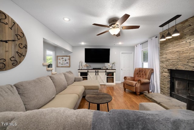 1008 Cox Trail Pl, Kingsport, TN 37660 - living room with a ceiling fan, wood finished floors, a fireplace, a textured ceiling, and recessed lighting