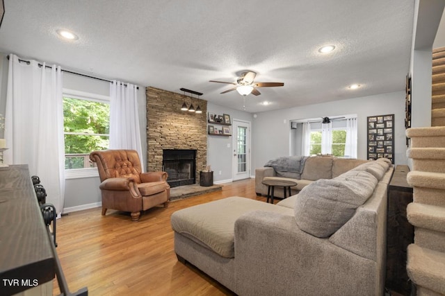 1008 Cox Trail Pl, Kingsport, TN 37660 - living room with a textured ceiling, a stone fireplace, healthy amount of natural light, a ceiling fan, and stairway