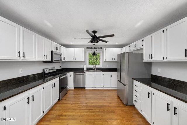 1008 Cox Trail Pl, Kingsport, TN 37660 - kitchen with stainless steel appliances, a ceiling fan, white cabinets, light wood-style floors, and recessed lighting