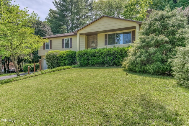 single story home featuring a garage, a chimney, brick siding, and a front yard