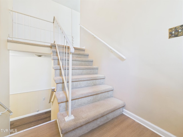 stairway with baseboards and wood finished floors