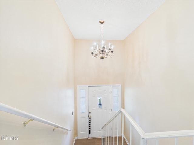 entryway with an inviting chandelier, baseboards, stairway, and wood finished floors