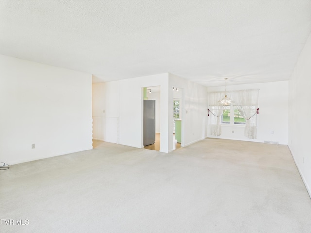 unfurnished living room with light colored carpet and a chandelier