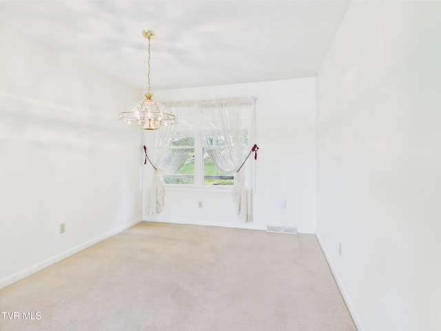 unfurnished room with baseboards, light carpet, a notable chandelier, and visible vents