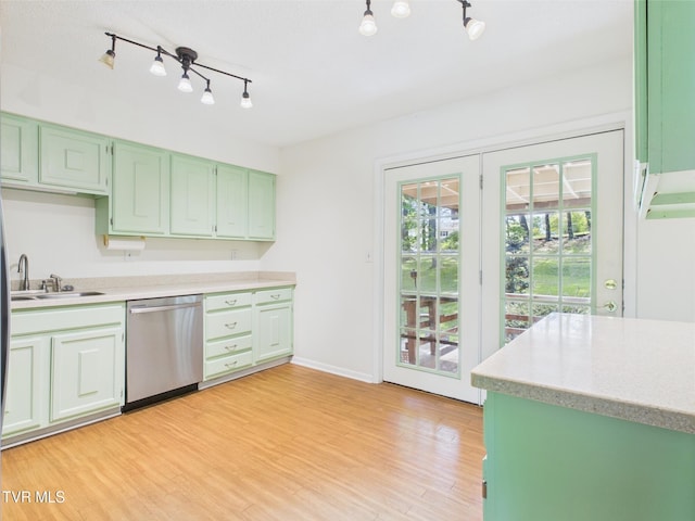kitchen featuring light countertops, rail lighting, a sink, light wood finished floors, and dishwasher