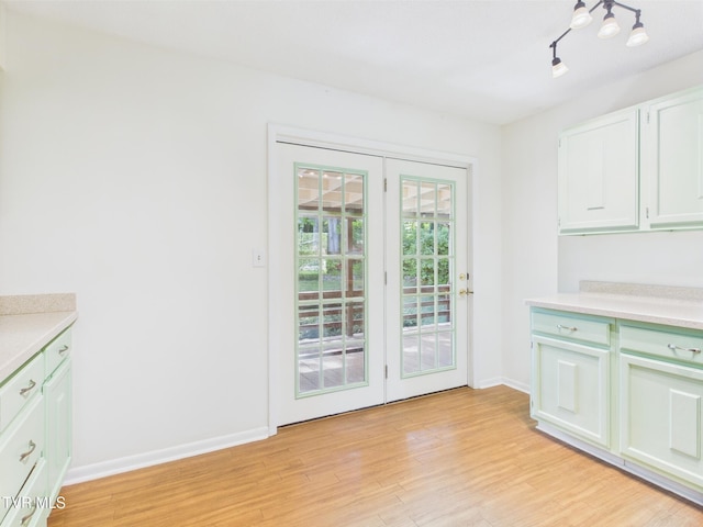 doorway featuring baseboards and light wood-type flooring