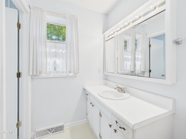 bathroom featuring visible vents, baseboards, and vanity