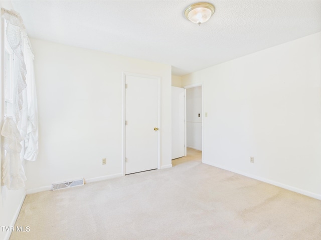 carpeted empty room with baseboards and visible vents