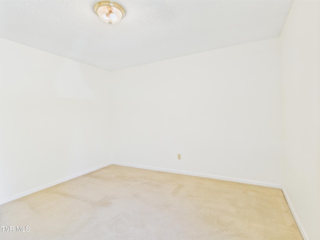 unfurnished room with baseboards and light carpet